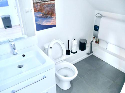 une salle de bain blanche avec des toilettes et un lavabo dans l'établissement Haven Home, à Melun