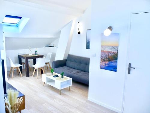 un salon avec un canapé et une table dans l'établissement Haven Home, à Melun