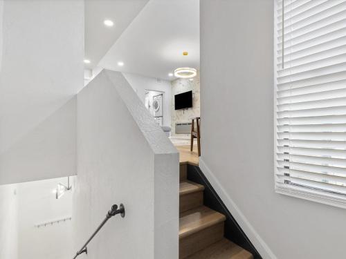 a staircase in a house with white walls and wooden floors at Lawrenceville Central !5 Spacious and Quiet Three Bedroom Apartment with Free Street Parking in Pittsburgh