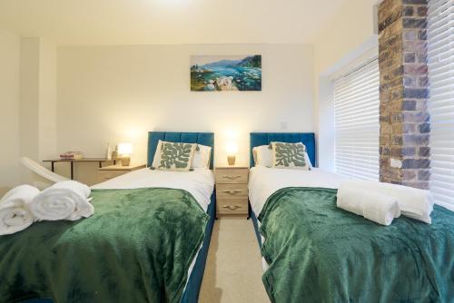 伯明翰Luxury Nostalgic City Centre Stay with Pool Table, Netflix, Sofa bed, Sleeps 6, Nostalgia Stays的卧室里有两张并排的床