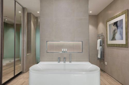 a white tub in a bathroom with a shower at The Westin Dragonara Resort, Malta in St Julian's