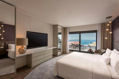 a hotel room with a bed and a television at The Westin Dragonara Resort, Malta in St Julian's