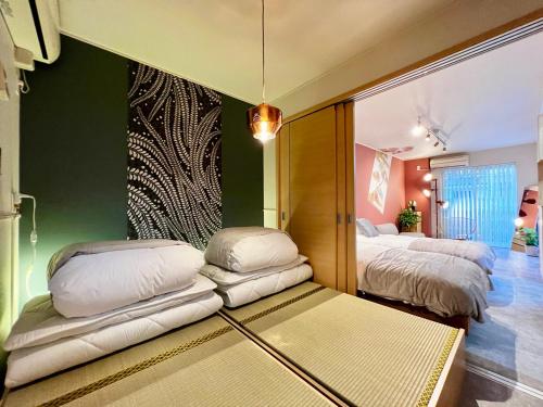 two beds with white pillows in a room at New open! Dream ASUNARO 5 minuites from Shinsaibashi in Osaka