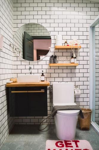 a bathroom with a sink and a toilet and a mirror at Baan Pila in Luang Prabang