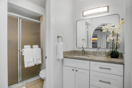 a bathroom with a toilet and a sink and a mirror at The Waterfront Fishing Retreat in Cape Coral