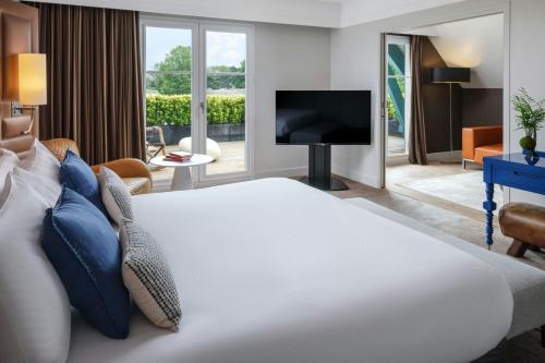 a hotel room with a bed and a television at Renaissance Paris Hippodrome de St. Cloud Hotel in Rueil-Malmaison