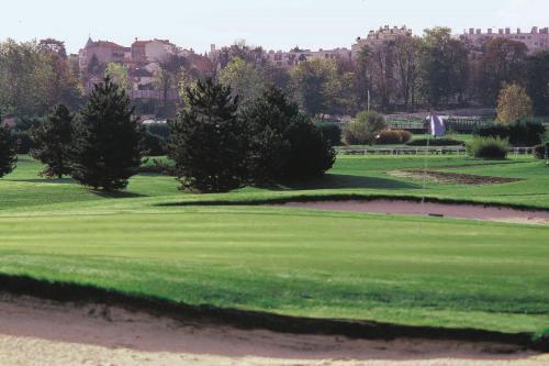 a golf course with trees and a green at Renaissance Paris Hippodrome de St. Cloud Hotel in Rueil-Malmaison