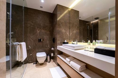a bathroom with a sink and a toilet and a shower at Courtyard by Marriott Vadodara in Vadodara