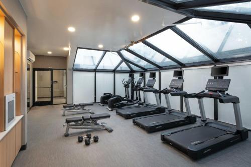 a gym with a row of treadmills and exercise equipment at Courtyard by Marriott Denver Central Park in Denver