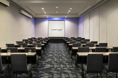 a conference room with tables and chairs and a screen at Courtyard by Marriott Long Beach Downtown in Long Beach