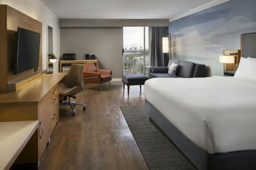 a hotel room with a bed and a desk and a television at Courtyard by Marriott Long Beach Downtown in Long Beach