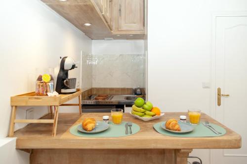 une cuisine avec une table et des assiettes de nourriture dans l'établissement Le Columba-Studio Parisien Saint-Germain, à Paris