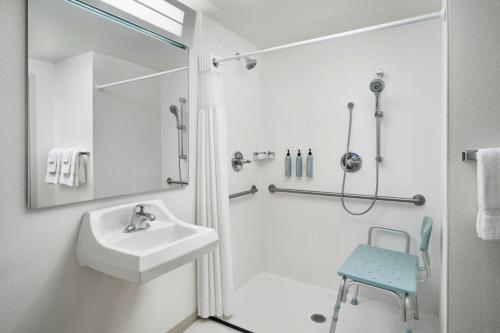 a white bathroom with a sink and a shower at Courtyard Baton Rouge South in Baton Rouge