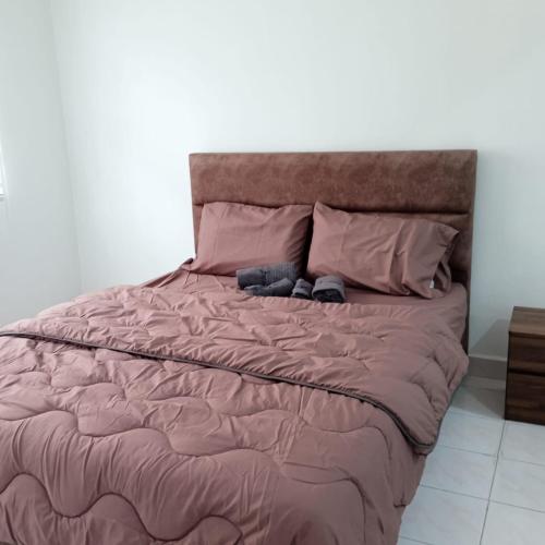 a large bed with pink comforter and pillows at Putra Heights Subang Jaya Paradise Property No 1 in Subang Jaya