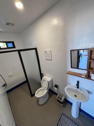 a bathroom with a toilet and a sink at Kattegat Beach Villas in El Nido