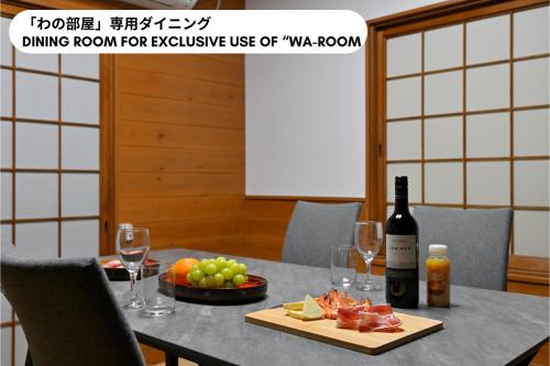 a table with a bottle of wine and a plate of fruit at わとなみ in Tonosho