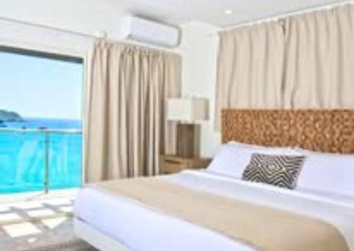 a bedroom with a large bed and a large window at Villa en Sea in Philipsburg