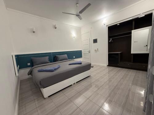 a bedroom with a bed with blue pillows on it at Paradise by Rashuthere Maldives in Rasdu