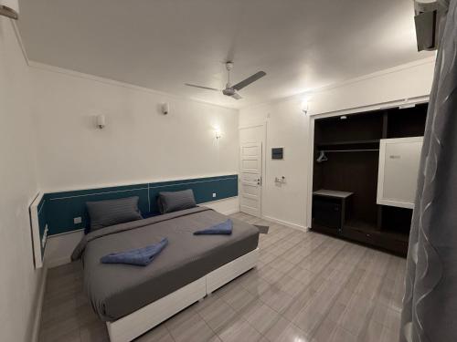 a bedroom with a bed with blue pillows on it at Paradise by Rashuthere Maldives in Rasdu