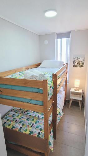 ein Schlafzimmer mit zwei Etagenbetten in einem Zimmer in der Unterkunft Bello departamento en el centro de Temuco in Temuco