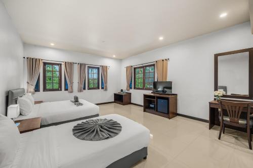 a bedroom with two beds and a desk and a television at SimPly Stay Fisherman's Village in Amphoe Koh Samui