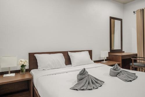 a bedroom with a large white bed with towels on it at SimPly Stay Fisherman's Village in Amphoe Koh Samui