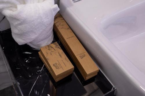 two wooden blocks on the side of a bath tub at Airbus Hotel At Phawana Station in Bangkok
