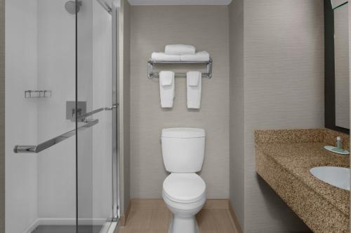 a bathroom with a toilet and a shower and a sink at Courtyard by Marriott Cypress Anaheim / Orange County in Cypress