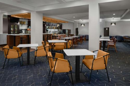 an empty restaurant with tables and chairs at Courtyard by Marriott Cypress Anaheim / Orange County in Cypress