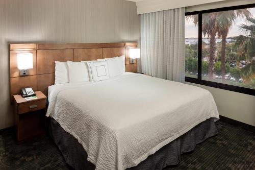 a hotel room with a large bed and a window at Courtyard by Marriott Cypress Anaheim / Orange County in Cypress