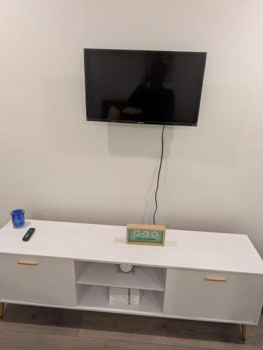 a white desk with a tv on a white wall at Joonam Luxury Room For You In Peachtree Corners with Private Bath in Peachtree Corners