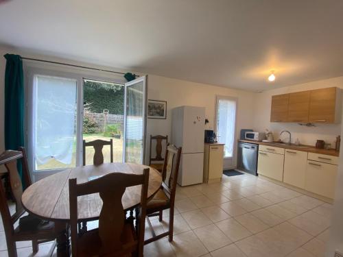 une cuisine et une salle à manger avec une table et un réfrigérateur dans l'établissement Maison 3 chambres près de la plage avec jardin privé et parking - FR-1-22-379, à Longeville-sur-Mer
