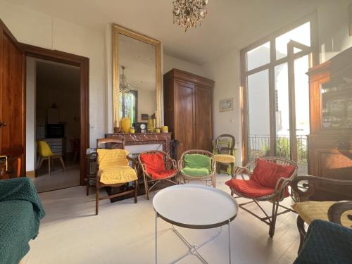 - un salon avec des chaises colorées et une table dans l'établissement Élégante Villa Arcachonnaise au cœur d'Arcachon - FR-1-474-271, à Arcachon