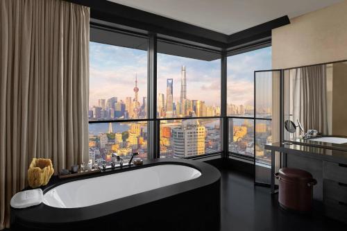 a bathroom with a bath tub and a large window at Bulgari Hotel Shanghai in Shanghai