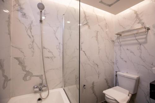 a bathroom with a shower and a toilet at Airbus Hotel At Phawana Station in Bangkok