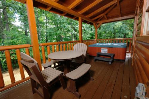 a porch with a table and chairs and a pool table at Arcade game, hottub, dog friendly 2 bedroom log cabin in Gatlinburg near Ober and the national park! in Gatlinburg