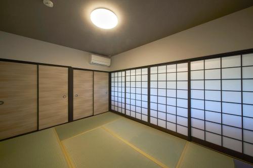 an empty room with wooden cabinets and a light bulb at おやど紀伊国屋丸山町 in Nagasaki