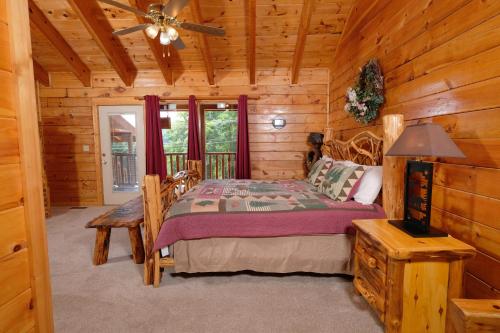 a bedroom with a bed in a log cabin at Arcade game, hottub, dog friendly 2 bedroom log cabin in Gatlinburg near Ober and the national park! in Gatlinburg