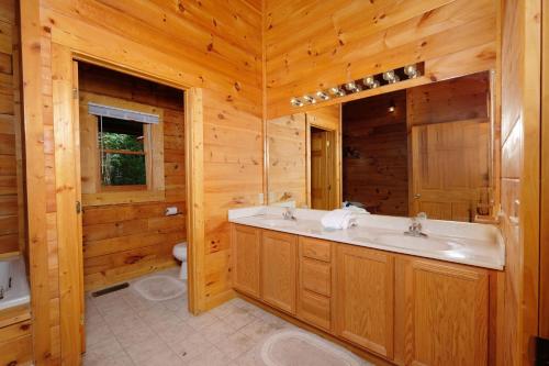 a bathroom with a sink and a tub and a toilet at Arcade game, hottub, dog friendly 2 bedroom log cabin in Gatlinburg near Ober and the national park! in Gatlinburg