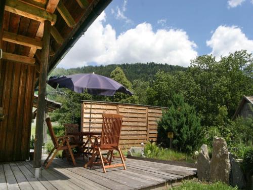 a table and chairs on a deck with an umbrella at Chalet in Einach near Ski Slopes in Stadl an der Mur