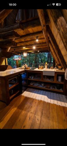 a large room with a kitchen with wooden floors at Bosque Veneza in Nova Veneza