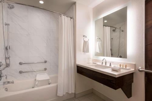 a bathroom with a tub and a sink and a shower at Renaissance Denver Downtown City Center Hotel in Denver