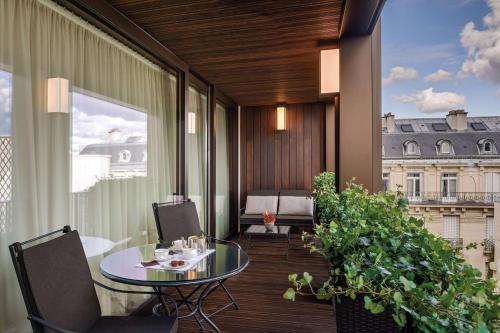 a balcony with a table and chairs and a window at Bvlgari Hotel Paris in Paris