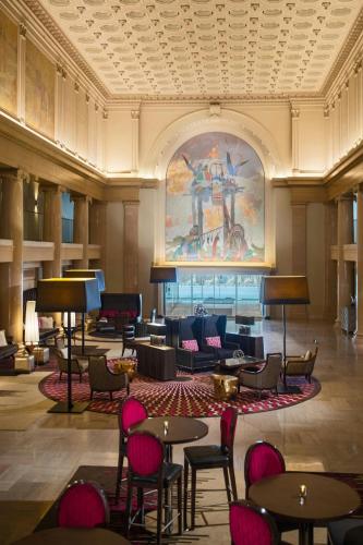 a lobby with tables and chairs and a large painting at Renaissance Denver Downtown City Center Hotel in Denver