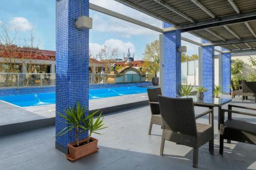 a patio with a table and chairs and a pool at AC Hotel Ciudad de Sevilla by Marriott in Seville