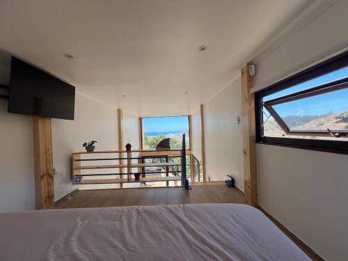 a bedroom with a bed and a large window at El Encanto, Loft en Matanzas in Matanzas