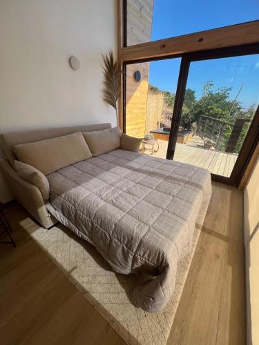 a bedroom with a bed and a large window at El Encanto, Loft en Matanzas in Matanzas
