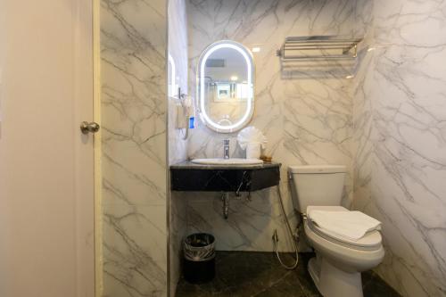 a bathroom with a toilet and a sink and a mirror at Airbus Hotel At Phawana Station in Bangkok