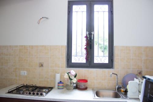 ジャッレにあるCasa Macchiaのキッチン(コンロ、シンク付)、窓2つが備わります。