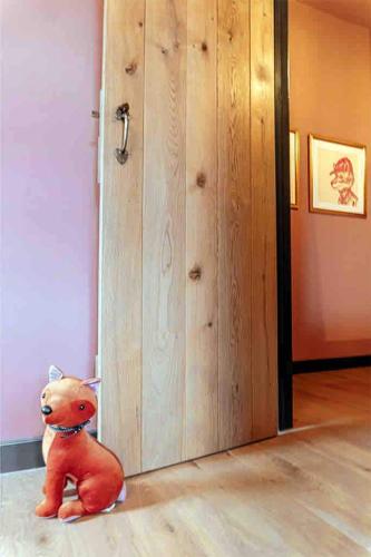 a teddy bear sitting on the floor next to a door at Old Chapel Llanfrynach in Brecon